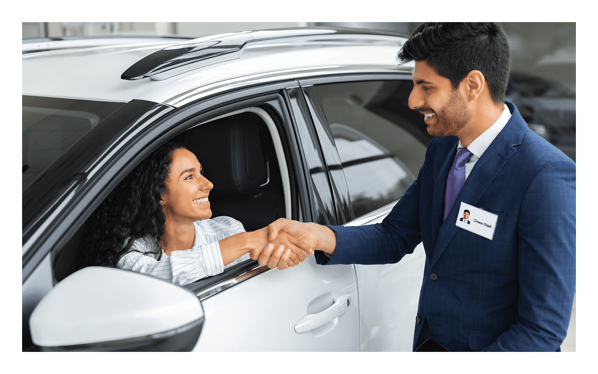 Woman in car greeting salesman